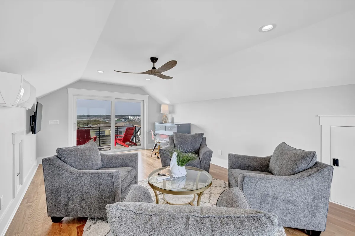 A bright, cozy indoor seating nook with two comfortable armchairs and a round glass coffee table positioned by large windows framing beautiful views. The inviting setup is perfect for relaxing with a book, enjoying conversations, or gazing out at the scenery, seamlessly connecting the interior comfort to the outside vistas.