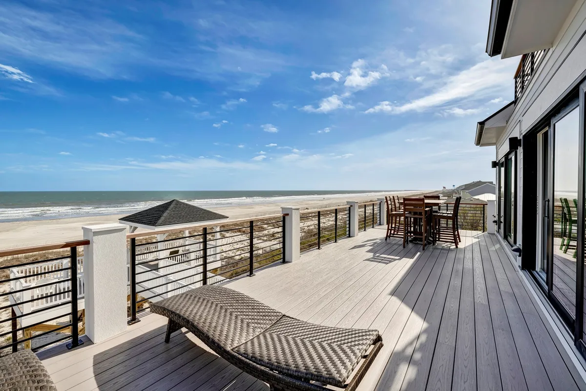 An expansive deck with outdoor seating, sun loungers, and an unobstructed ocean view. The deck invites guests to relax, dine al fresco, and enjoy the fresh air, connecting the interior living spaces to the natural beauty of the seaside location.