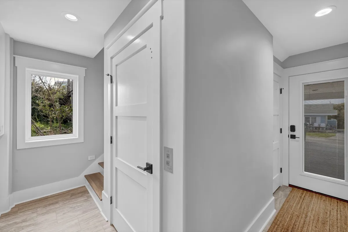 A welcoming entryway with a front door, staircase, and a bright window letting in natural light. The inviting atmosphere, with clean lines and a sense of openness, hints at easy arrivals and convenient movement throughout the home, including elevator access.