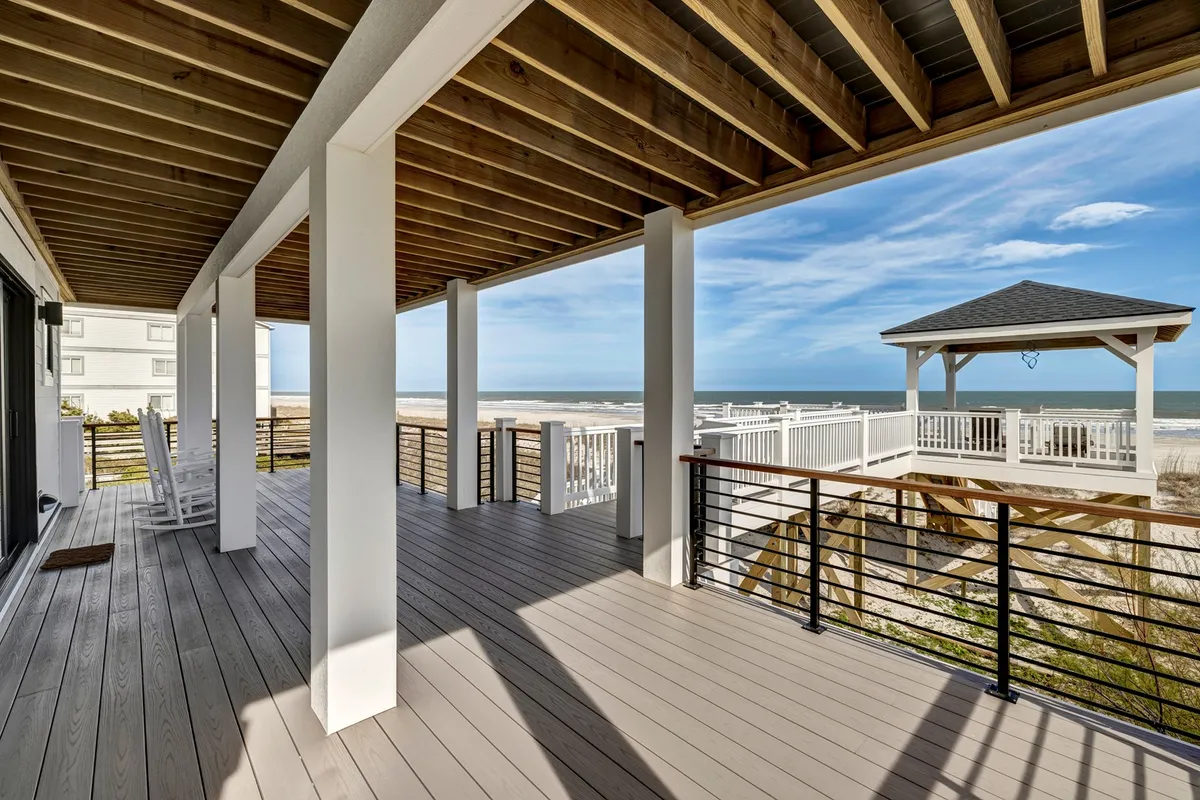 An expansive deck overlooks the ocean, with a cozy gazebo providing shade and ample space for entertaining or quiet moments. The deck's railings and surrounding ocean vista invite guests to take in sunset views and ocean breezes, while the gazebo adds a special feature for gatherings or private reflection.